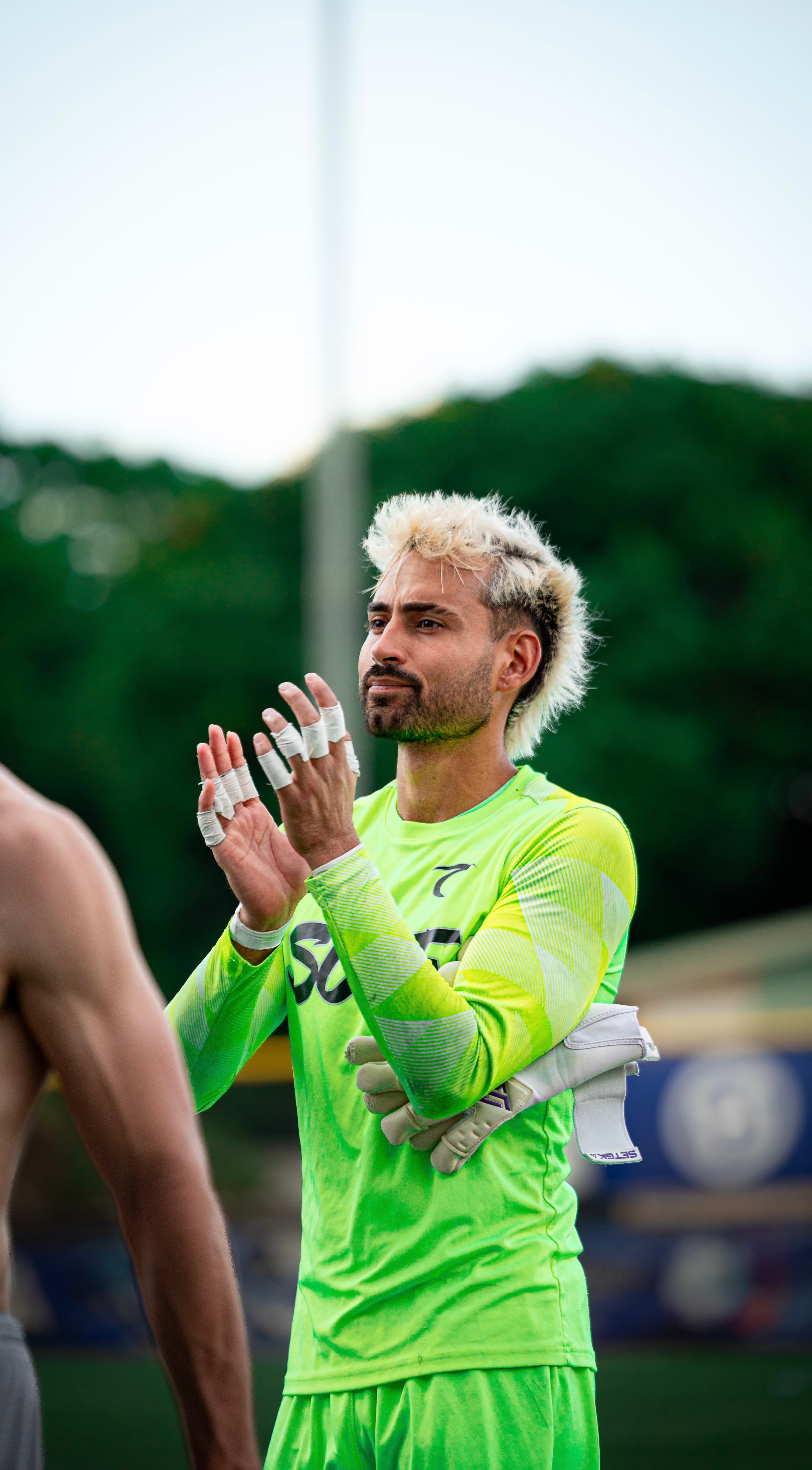 Lucas Espada applauding the crowd after a match, hands taped